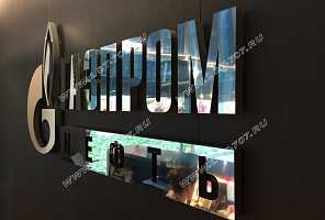 Имиджевая стена компании ПАО «Газпром нефть» с зеркальным объемным металлическим логотипом из нержавеющей стали.